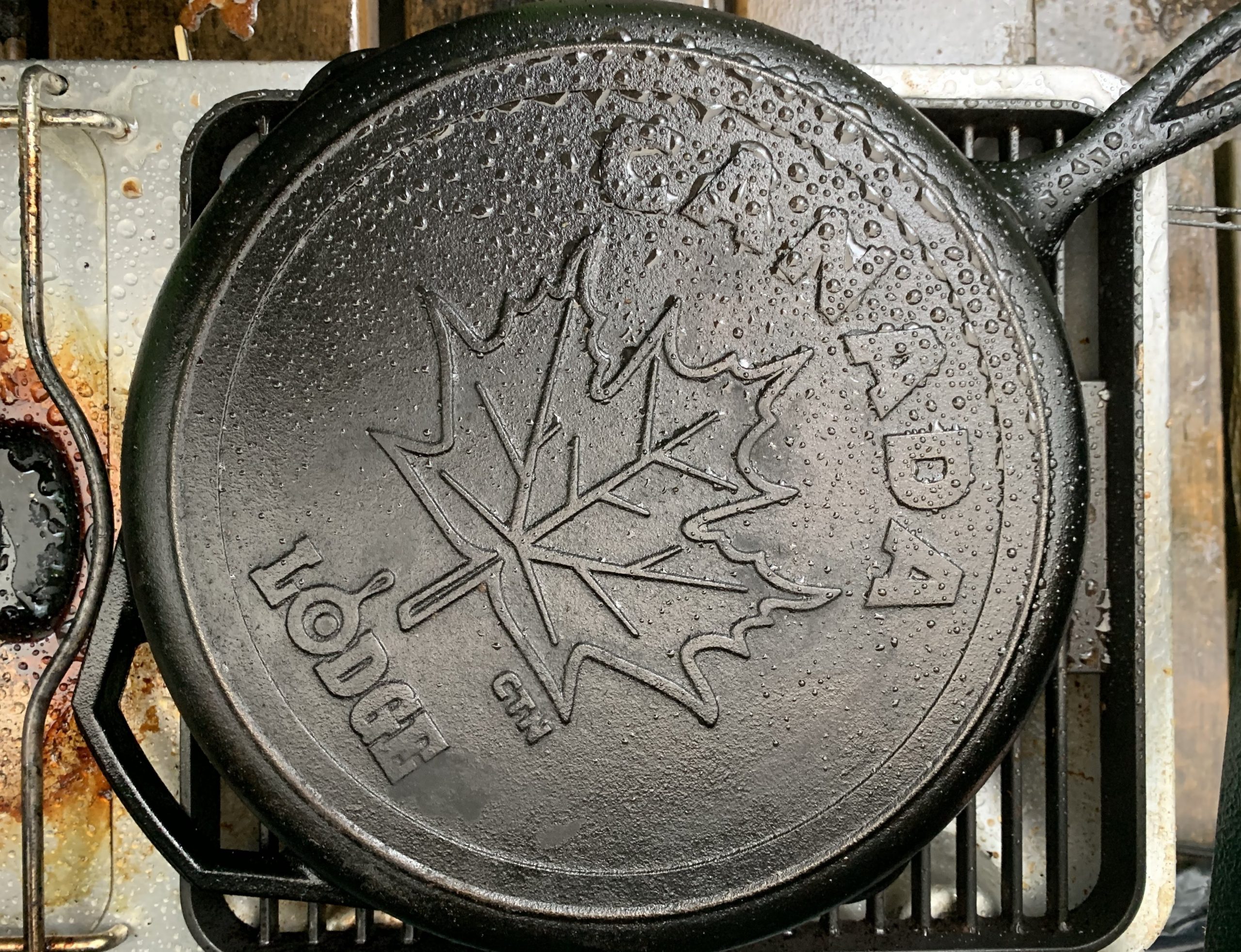 The back of a large cast iron pan with an embossed maple leaf.